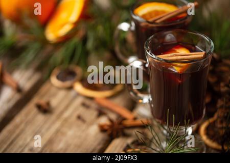 Appetitliche weihnachtliche Komposition Gläser Glühwein auf Fichtenkegel und Ast Hintergrund. Duftende Gewürze. Festliche Stimmung. Heiße alkoholische Getränke. Vie Stockfoto