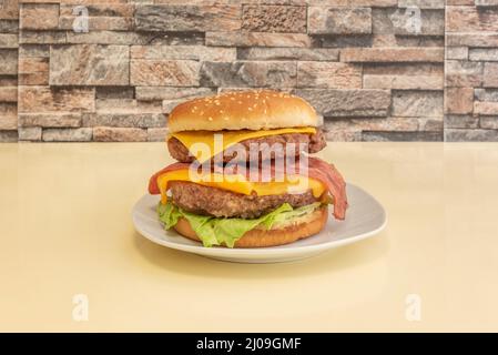 Der Doppel-Burger mit zwei Fleischstücken gewürzt mit einem Schuss Salz und Pfeffer Ketchup und Cheddar-Käse auf einem Rahmentisch, mit frischem Salat und Stockfoto