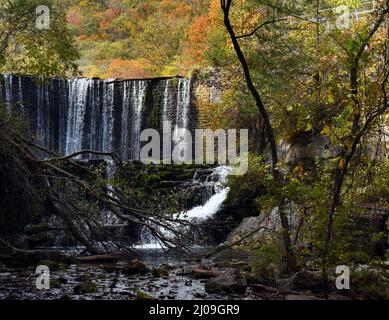 Blick auf den Fuß des Mirror Lake Waterfall. Stone Spillway dämmt den See, lässt aber Wasser über den Damm auslaufen. Herbstblätter füllen den Himmel am Blanchard Stockfoto