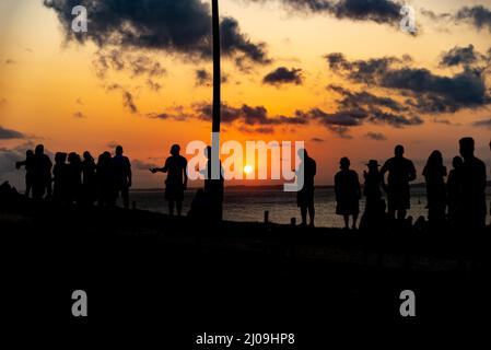 Silhouette von Menschen und Kreuzen, die auf dem Boden zu Ehren der von Covid-19 Getöteten befestigt sind. Sonnenuntergang in Salva Stockfoto