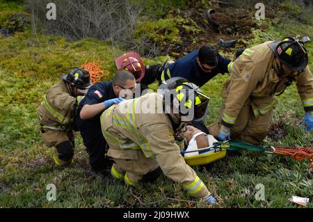 San Diego Feuerwehr-Rettungskräfte von den Stationen 20 und 36, die eine technische Rettung eines Fahrers bei einem überfahrenden Unfall im Gelände durchführen. Stockfoto