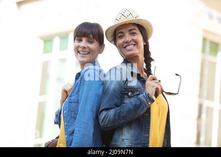 Glückliche aufschlussreiche positive Momente von zwei stilvollen Mädchen auf der Straße Stockfoto