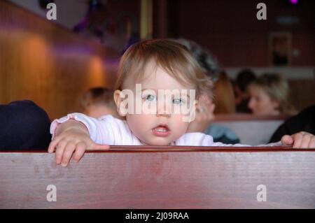 Sehr junge Kinder und Kleinkinder im Café, die sich beim Mittagessen mit der Großfamilie vor Brüdern und Schwestern und der Familie zeigen Stockfoto