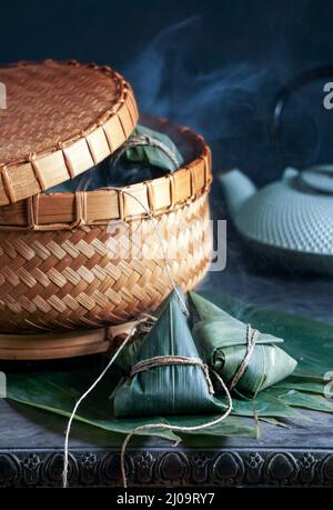 Zongzi Reisknödel шт ein Dampfer für das traditionelle chinesische Drachenbootfest (Duanwu Festival) auf dunkelschwarzem Hintergrund Stockfoto