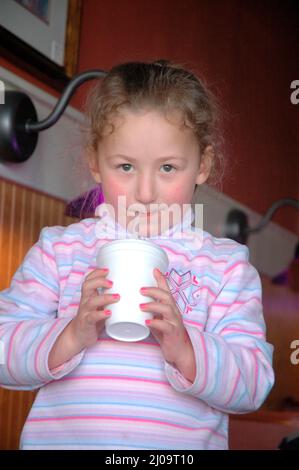 Sehr junge Kinder und Kleinkinder im Café, die sich beim Mittagessen mit der Großfamilie vor Brüdern und Schwestern und der Familie zeigen Stockfoto