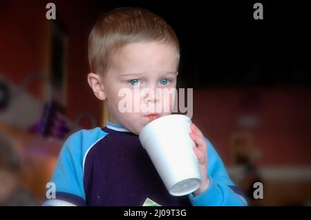 Sehr junge Kinder und Kleinkinder im Café, die sich beim Mittagessen mit der Großfamilie vor Brüdern und Schwestern und der Familie zeigen Stockfoto