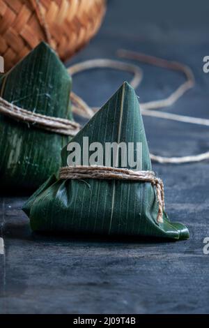 Zongzi Reisknödel шт ein Dampfer für das traditionelle chinesische Drachenbootfest (Duanwu Festival) auf dunkelschwarzem Hintergrund Stockfoto