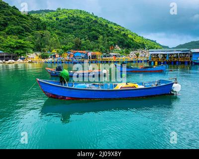 Kleine blaue Fischerboote liegen an den Docks in den Fischrestaurants. Stockfoto