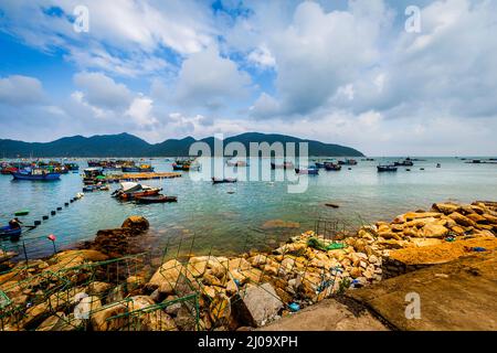 Ein kleines Fischerdorf in der Vu Bay. Viele Fischerboote sind nach dem Nachtangeln an Land. Stockfoto