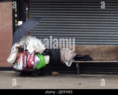 17. März 2022, New York, New York, USA: 17. März, 2022 New York, . Rainy Day Obdachlose, die auf einer Bank in Sheepshead Bay, Brooklyn, New York, schlafen. (Bild: © Bruce Cotler/ZUMA Press Wire) Stockfoto