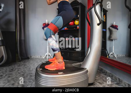 Eine Frau, die auf der Powerplate-Maschine trainiert, verwendet die Powerplate für das Training Stockfoto