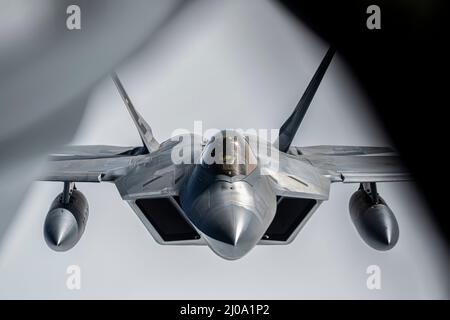 Ein F-22 Raptor, der der Alaska NORAD Region zugewiesen wurde, fliegt während der Operation NOBLE DEFENDER über dem Golf von Alaska am 16. März 2022 hinter einem KC-135R Stratotanker. NOBLE DEFENDER ist eine Luftverteidigungsoperation des North American Aerospace Defense Command, bei der US-Streitkräfte mit Sicherheits- und Verteidigungspartnern zusammenarbeiten, um eine integrierte Abschreckung zu gewährleisten und Bedrohungen von allen möglichen Wegen aus zu schützen. (USA Luftwaffe Foto von Senior Airman Joseph P. LeVeille) Stockfoto