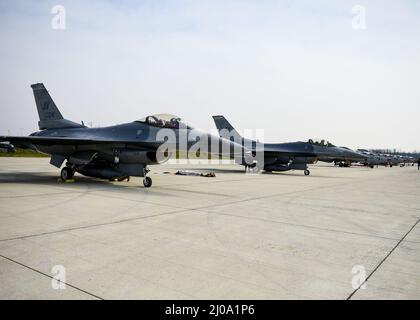 Zwei Kampfflugzeuge der US-Luftwaffe F-16C Fighting Falcon, die dem 555.-Jagdgeschwader des 31.-Jagdflügels, der Aviano Air Base, Italien, zugewiesen wurden, feuern Jets neben kroatischen MiG-21-Flugzeugen an, die dem 191.-Jagdgeschwader auf dem kroatischen 91.-Luftwaffenstützpunkt in Pleso zugewiesen wurden, 17. März 2022. Die FW von 31. führte während dieses Fluges routinemäßige agile Combat Employment-Operationen mit kroatischen Alliierten durch. Solche Missionen erhöhen die notwendige Bereitschaft, auf jede mögliche Herausforderung in Südosteuropa zu reagieren. (USA Air Force Foto von Tech. Sgt. Miquel Jordan) Stockfoto