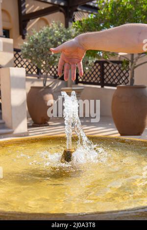 Im Sommer arbeitet im Garten ein kleiner Brunnen Stockfoto