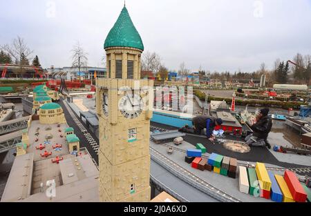 16. März 2022, Bayern, Günzburg: Mitarbeiter des Freizeitparks Legoland bereiten für die Saisoneröffnung am 2. April 2022 ein Modell der Stadt Hamburg vor, das aus Legosteinen in Miniland nachgebildet wurde. Gleichzeitig baut Legoland einen Themenbereich mit einer neuen Achterbahn. Die Eröffnung auf einer Fläche von 1,2 Hektar ist für 2023 geplant. Foto: Karl-Josef Hildenbrand/dpa Stockfoto