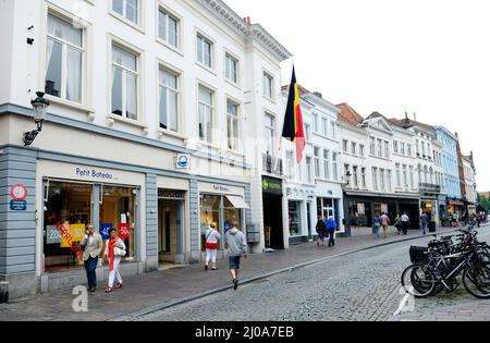 Zuidzandstraat gesäumt von Geschäften und Cafés im alten historischen Zentrum von Brügge, Belgien. Stockfoto