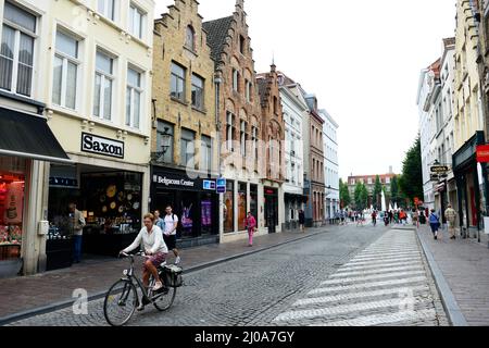 Zuidzandstraat gesäumt von Geschäften und Cafés im alten historischen Zentrum von Brügge, Belgien. Stockfoto