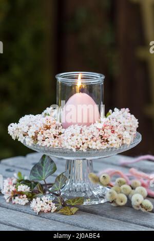 Romantische Blumendekoration mit Rosenblüten und Kerze Stockfoto