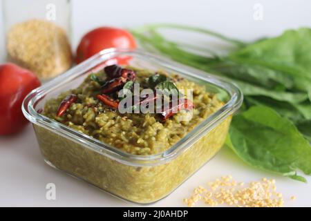 Ein Topf Zubereitung aus Basmati-Reis, gelben Mungellentilen, blanchierten und pürierten Spinat und Gewürzen. Allgemein bekannt als Palak khichdi. Auf Weiß geschossen Stockfoto