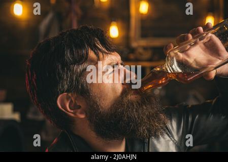 Verärgert Mann Trinker Alkoholiker mit Glas trinken Whisky allein, traurig depressiv süchtig. Alkoholabhängigkeit, betrunkener Mann. Stockfoto