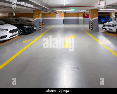 Unterirdische, mehrstöckige öffentliche, moderne Garagenparkplätze mit Autos, Innenparkplatz Foto Stockfoto