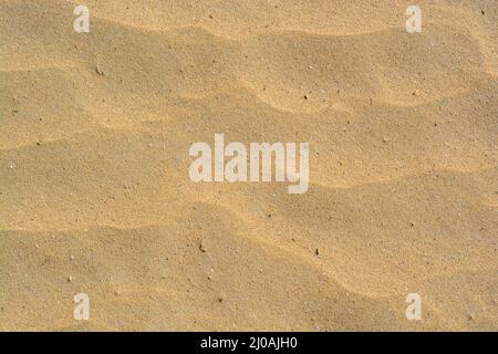 Struktur oder Muster aus goldenem Sand Stockfoto