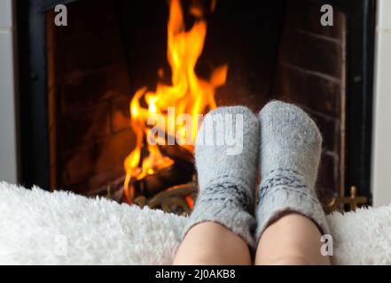 Kinderfüße sind im Kamin beheizt. Stockfoto