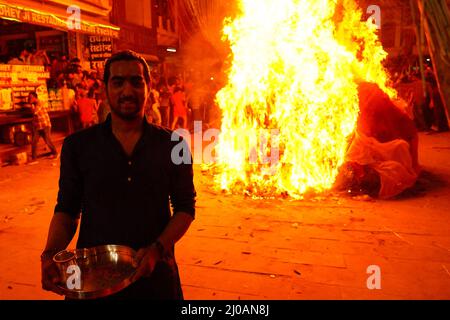 Rajasthan, Indien. 17. März 2022. Die Inder versammeln sich am Lagerfeuer, um am 17. März 2022 in Pushkar, Rajasthan, Indien, die „Holika Dahan“ zu feiern und zu beten. Holika Dahan, oder das Brennen des Dämons Holika, wird in der Nacht vor dem Holi-Fest gefeiert und soll der Flucht von Prahlad (Anhänger von lord Vishnu) vor dem Brand gedenken, wenn sie von Demoness Holika ins Feuer getragen wird. Das Lagerfeuer symbolisiert den Sieg des Guten über das Böse. Foto von ABACAPRESS.COM Quelle: Abaca Press/Alamy Live News Stockfoto