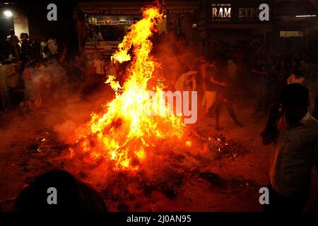 Rajasthan, Indien. 17. März 2022. Die Inder versammeln sich am Lagerfeuer, um am 17. März 2022 in Pushkar, Rajasthan, Indien, die „Holika Dahan“ zu feiern und zu beten. Holika Dahan, oder das Brennen des Dämons Holika, wird in der Nacht vor dem Holi-Fest gefeiert und soll der Flucht von Prahlad (Anhänger von lord Vishnu) vor dem Brand gedenken, wenn sie von Demoness Holika ins Feuer getragen wird. Das Lagerfeuer symbolisiert den Sieg des Guten über das Böse. Foto von ABACAPRESS.COM Quelle: Abaca Press/Alamy Live News Stockfoto