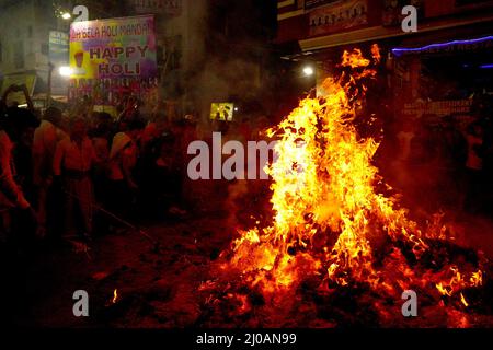 Rajasthan, Indien. 17. März 2022. Die Inder versammeln sich am Lagerfeuer, um am 17. März 2022 in Pushkar, Rajasthan, Indien, die „Holika Dahan“ zu feiern und zu beten. Holika Dahan, oder das Brennen des Dämons Holika, wird in der Nacht vor dem Holi-Fest gefeiert und soll der Flucht von Prahlad (Anhänger von lord Vishnu) vor dem Brand gedenken, wenn sie von Demoness Holika ins Feuer getragen wird. Das Lagerfeuer symbolisiert den Sieg des Guten über das Böse. Foto von ABACAPRESS.COM Quelle: Abaca Press/Alamy Live News Stockfoto