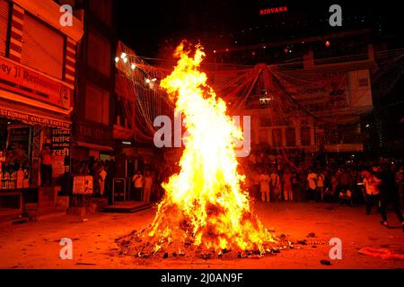 Rajasthan, Indien. 17. März 2022. Die Inder versammeln sich am Lagerfeuer, um am 17. März 2022 in Pushkar, Rajasthan, Indien, die „Holika Dahan“ zu feiern und zu beten. Holika Dahan, oder das Brennen des Dämons Holika, wird in der Nacht vor dem Holi-Fest gefeiert und soll der Flucht von Prahlad (Anhänger von lord Vishnu) vor dem Brand gedenken, wenn sie von Demoness Holika ins Feuer getragen wird. Das Lagerfeuer symbolisiert den Sieg des Guten über das Böse. Foto von ABACAPRESS.COM Quelle: Abaca Press/Alamy Live News Stockfoto