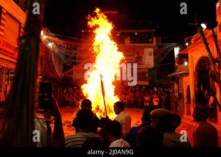 Rajasthan, Indien. 17. März 2022. Die Inder versammeln sich am Lagerfeuer, um am 17. März 2022 in Pushkar, Rajasthan, Indien, die „Holika Dahan“ zu feiern und zu beten. Holika Dahan, oder das Brennen des Dämons Holika, wird in der Nacht vor dem Holi-Fest gefeiert und soll der Flucht von Prahlad (Anhänger von lord Vishnu) vor dem Brand gedenken, wenn sie von Demoness Holika ins Feuer getragen wird. Das Lagerfeuer symbolisiert den Sieg des Guten über das Böse. Foto von ABACAPRESS.COM Quelle: Abaca Press/Alamy Live News Stockfoto