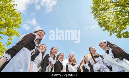 Lächelnde weibliche Absolventen posieren am letzten Tag des Schullebens. Stockfoto