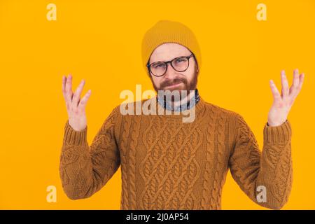 Porträt des jungen bärtigen kaukasischen Mann in Brille und Hut zuckende Schultern Befragung Geste Konzept Hipster isoliert Studio-Aufnahme . Hochwertige Fotos Stockfoto