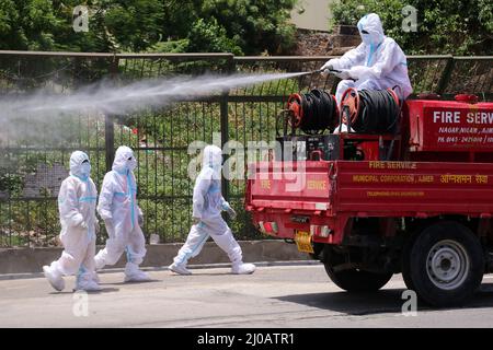 Indischer Stadtarbeiter sprüht Desinfektionsmittel auf seine Kollegen, nachdem sie am 19. Juni 2020 den Leichnam eines COVID-19-Opfers in einem Krematorium in Ajmer, Rajasthan, Indien, eingeäschert haben. Foto von ABACAPRESS.COM Stockfoto