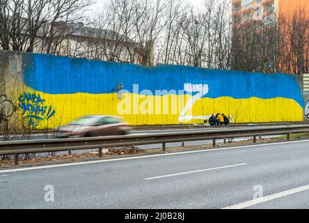 Teplice, Tschechische Republik. 17. März 2022. Forensische Wissenschaftler suchten am 17. März 2022 nach Spuren um den weißen Großbuchstaben Z, der an der Wand, die die Strecke durch die Stadt Teplice, Tschechische Republik, mit den Farben der ukrainischen Flagge, umgab. In Russland wird beispielsweise der Buchstabe Z auf Autos, Häuser oder Kleidung gesetzt. Sie drücken ihre Unterstützung für die russischen Streitkräfte in der Ukraine aus. Die Inschrift auf der linken Seite liest der Ukraine Ruhm vor. Quelle: Ondrej Hajek/CTK Photo/Alamy Live News Stockfoto