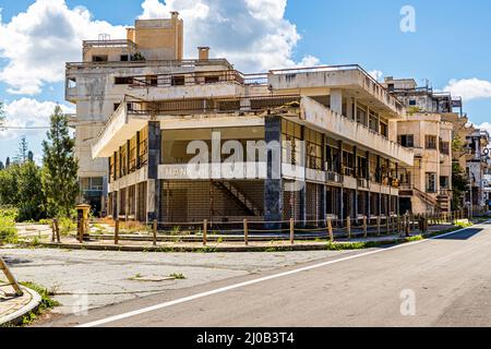 Der Bezirk Varosha (Kapalı Maraş) in Famagusta (Zypern) war zwischen 1970 und 1974 eines der beliebtesten Reiseziele der Welt. Die griechisch-zyprischen Einwohner flohen 1974 während der türkischen Invasion auf Zypern, als die Stadt Famagusta unter türkische Kontrolle kam. Seither ist sie verlassen und die Gebäude sind verfallen. Eine Handvoll Straßen im Resort wurden umgebaut, um die Erkundung zu erleichtern. Es ist sogar möglich, ein Fahrrad zu mieten, sobald Sie den Militärkontrollpunkt passieren – obwohl es nur ein paar Straßen offen gibt und die Gegend klein genug ist, um zu Fuß zu gehen Stockfoto