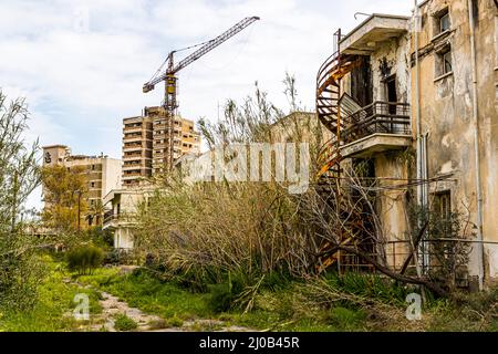 Viele Gebäude in Varosha wurden noch im Jahr 1974 gebaut. Der Bezirk Varosha (Kapalı Maraş) in Famagusta (Zypern) war zwischen 1970 und 1974 eines der beliebtesten Touristenziele der Welt. Seine griechisch-zyprischen Einwohner flohen während der türkischen Invasion Zyperns im Jahr 1974, als die Stadt Famagusta unter türkische Kontrolle kam. Seitdem ist es verlassen geblieben und die Gebäude sind verfault. Stockfoto