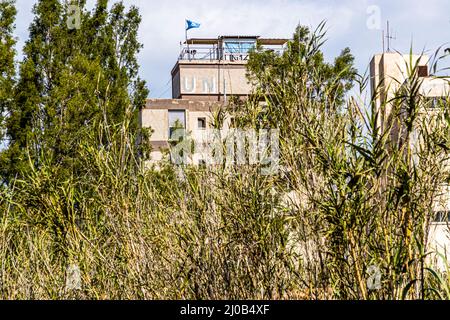 UN-Gebäude in der Gegend von Maras / Varosha, das noch immer belagert wird. Der Bezirk Varosha (Kapalı Maraş) in Famagusta (Zypern) war zwischen 1970 und 1974 eines der beliebtesten Touristenziele der Welt. Seine griechisch-zyprischen Einwohner flohen während der türkischen Invasion Zyperns im Jahr 1974, als die Stadt Famagusta unter türkische Kontrolle kam. Seitdem ist es verlassen geblieben und die Gebäude sind verfault. Stockfoto