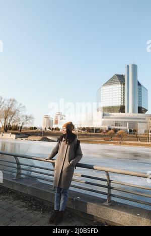 Eine Touristenfrau genießt den Blick auf das Stadtbild der Nationalbibliothek von Belarus in Minsk, im Frühling Stockfoto