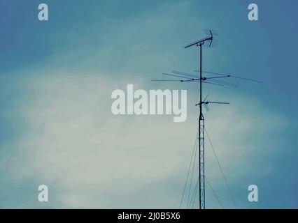 TV-Antenne auf dem Dach des Gebäudes und blauer Himmel Stockfoto