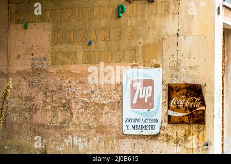 7up, Coca Cola und griechische Schrift. Die griechischen Zyprer begannen Anfang 1950s, Varosia als Vorort von Famagusta zu errichten. Der Bezirk Varosha (Kapalı Maraş) in Famagusta (Zypern) war zwischen 1970 und 1974 eines der beliebtesten Touristenziele der Welt. Seine griechisch-zyprischen Einwohner flohen während der türkischen Invasion Zyperns im Jahr 1974, als die Stadt Famagusta unter türkische Kontrolle kam. Seitdem ist es verlassen geblieben und die Gebäude sind verfault. Stockfoto