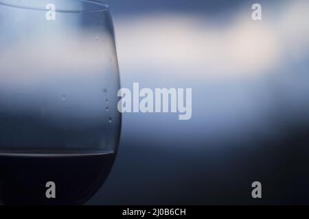 Nahaufnahme Makroglas Rotwein vor blauem Himmel Stockfoto