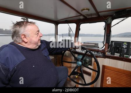 Saalburg Ebersdorf, Deutschland. 17. März 2022. Kapitän Klaus-Peter Pretzsch sitzt am Steuer des Thüringer Meeres. Die drei Schiffe der Reederei Stausee liegen an den Ufern des Bleiloch-Staudamms. Hier werden sie auf die Saison vorbereitet. (To dpa: Sieben Zeichen des Frühlingserwachens in Thüringen) Quelle: Bodo Schackow/dpa-zentralbild/dpa/Alamy Live News Stockfoto