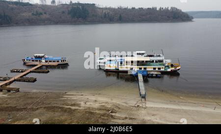 Saalburg Ebersdorf, Deutschland. 17. März 2022. Die Schiffe der Stausee-Navigation liegen am Ufer der Bleilochtalsperre. Hier sind sie auf die Saison vorbereitet.(Foto aufgenommen mit einer Drohne). (To dpa: Sieben Zeichen des Frühlingserwachens in Thüringen) Quelle: Bodo Schackow/dpa-zentralbild/dpa/Alamy Live News Stockfoto