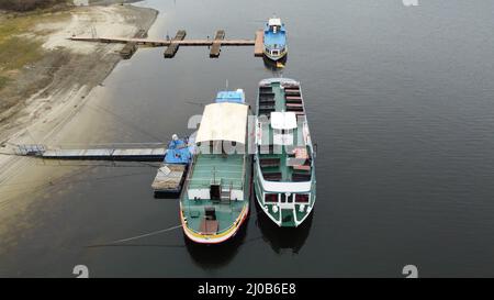 Saalburg Ebersdorf, Deutschland. 17. März 2022. Die Schiffe der Stausee-Navigation liegen am Ufer des Bleiloch-Staudamms. Hier sind sie auf die Saison vorbereitet.(Foto aufgenommen mit einer Drohne) (to dpa: Sieben Zeichen des Frühlingserwachens in Thüringen) Quelle: Bodo Schackow/dpa-zentralbild/dpa/Alamy Live News Stockfoto