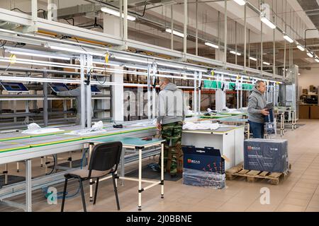 Minsk, Weißrussland - 15. Dezember 2021: Foto einer Anlage zur Montage von Monoblocks für Computer. Arbeiter arbeiten am Förderband Stockfoto