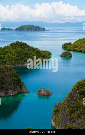 Kleine grüne Inseln gehören zu Fam-Insel im Meer von Raja Ampat, Papua-Neu-Guinea Stockfoto