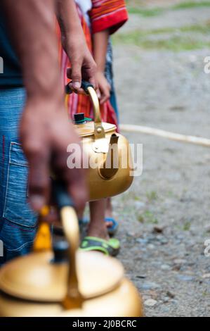 Schlange von Menschen mit goldenen Topf in der hand Stockfoto