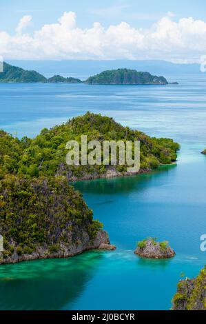 Kleine grüne Inseln gehören zu Fam-Insel im Meer von Raja Ampat, Papua-Neu-Guinea Stockfoto